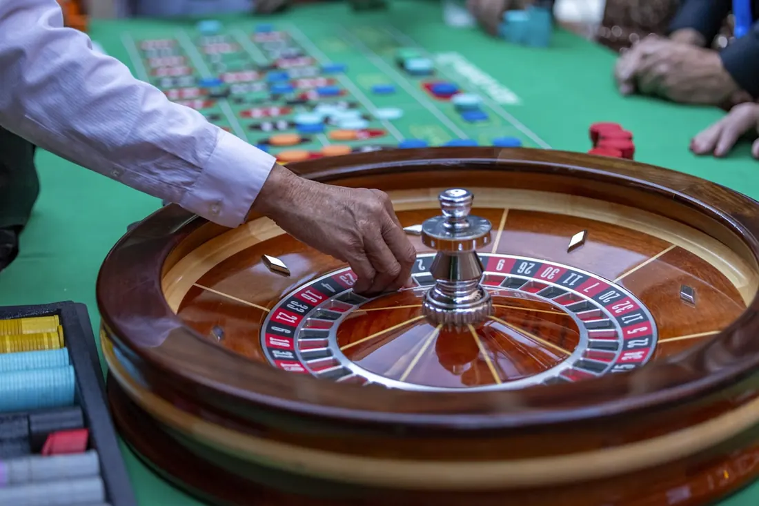 Meja roulette kasino dengan roda dan kain hijau